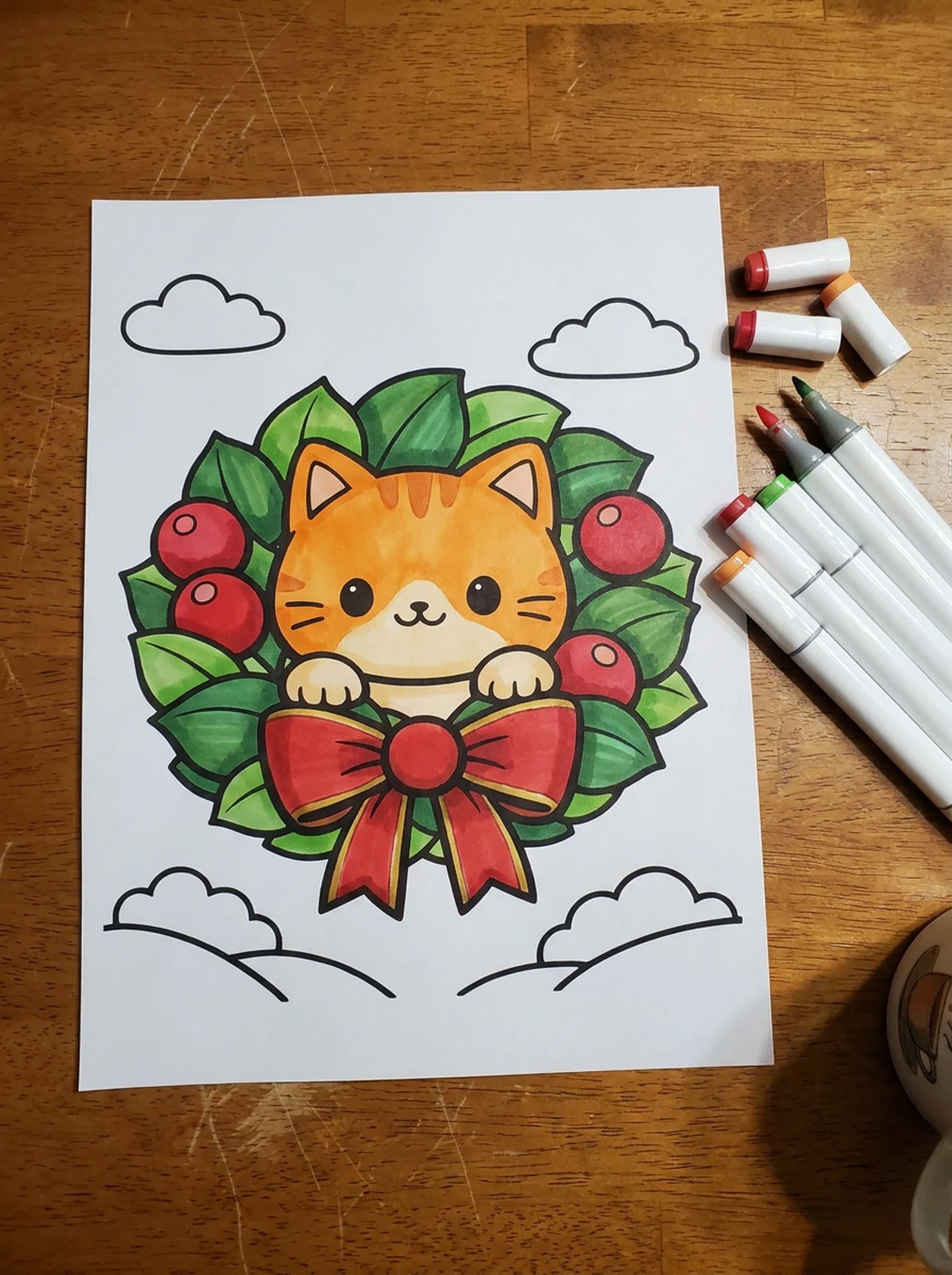 Cat Peeking Through a Christmas Wreath coloring page printed and half colored with markers