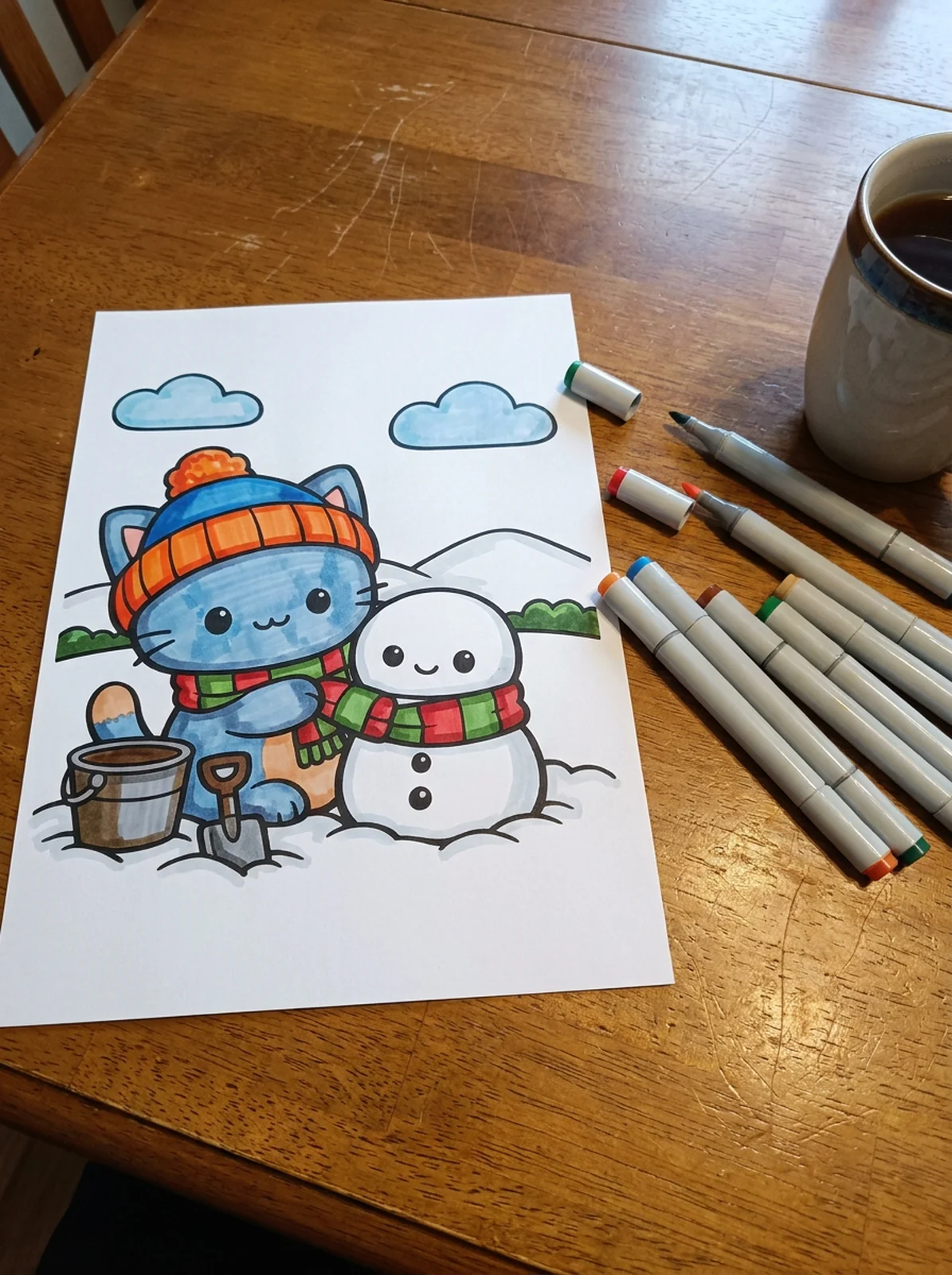 Kitten Building a Snowman coloring page printed and half colored with markers