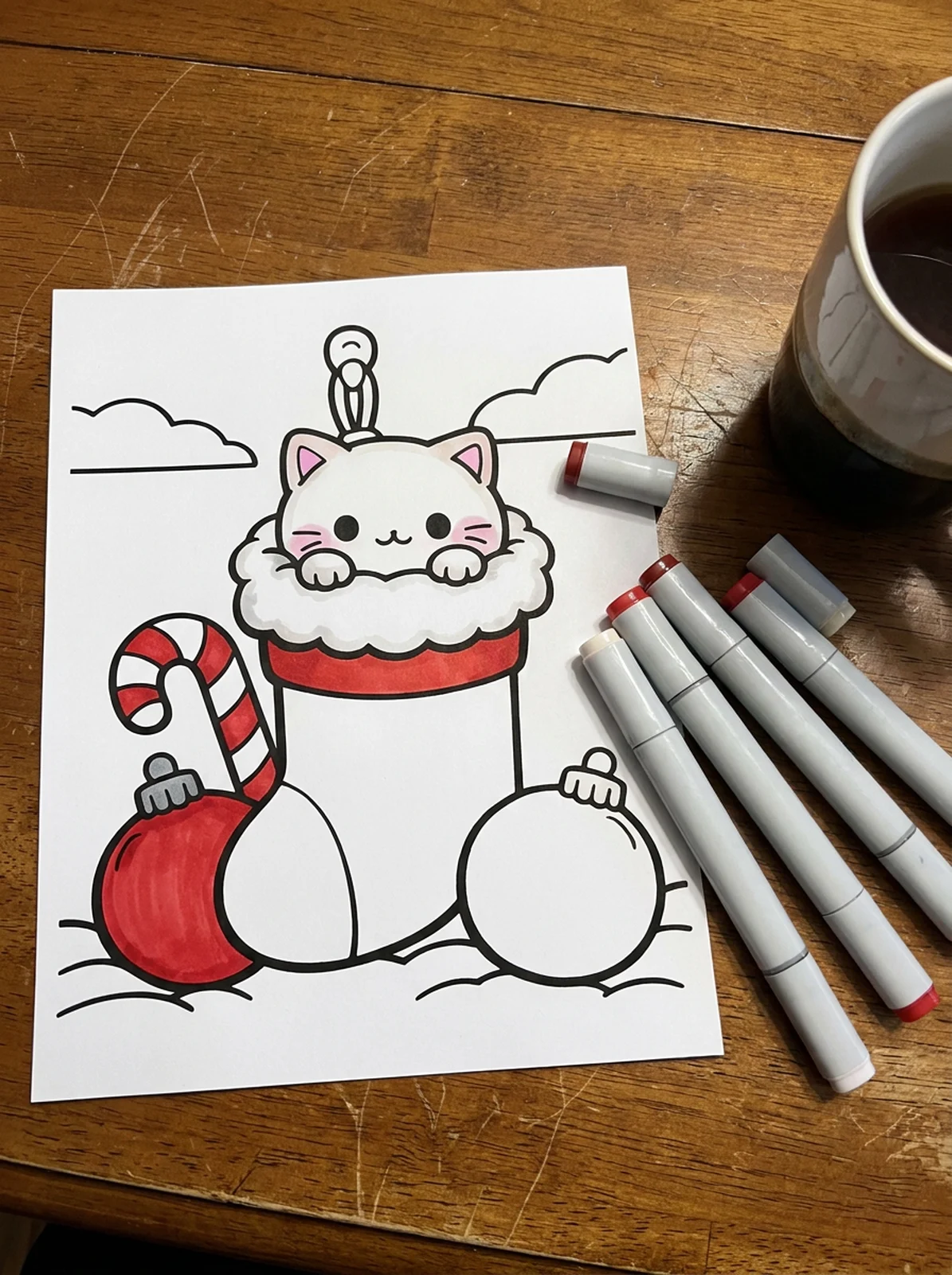 Kitten in a Christmas Stocking coloring page printed and half colored with markers